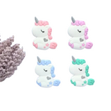 A collection of unicorn-shaped silicone teethers in various colors, including pink, blue, green, and purple, designed to be used by infants.