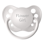 A white orthodontic pacifier with the engraved text 'Flower Girl' and includes clear protective cap attached.