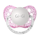 A pink orthodontic pacifier with the engraved text 'Gi-Gi' on the front, featuring a silicone nipple and a clear protective cap.