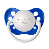A dark blue pacifier with a silicone orthodontic nipple, engraved with the phrase 'Grammy's Man'.
