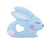 A silicone teether in the shape of a  bunny rabbit with long ears and a heart-shaped cutout in the center.