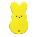A silicone teether in the shape of a yellow bunny with a simple design, featuring black eyes and a small hole at the bottom.