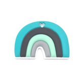 A cylindrical silicone teether with a rainbow design and a heart-shaped cut-out in the center. The teether is predominantly green with black and gray accents at the bottom.